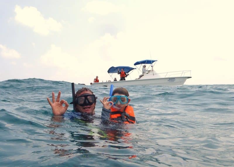 Pessoas com snorkel na superfície do mar, flutuando e observando o fundo marinho.