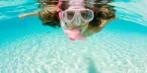 mulher a fazer snorkeling em aguas cristalinas