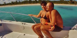 Casal em uma lancha no mar, aproveitando o passeio sob o sol.