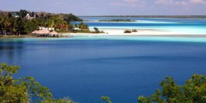 Vista paradisíaca da Lagoa de Bacalar, conhecida por suas águas azuis e seu ambiente sereno cercado pela natureza.
