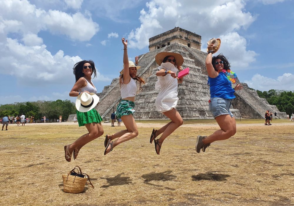 Viajantes explorando o sítio arqueológico de Chichén Itzá com a Exploratours