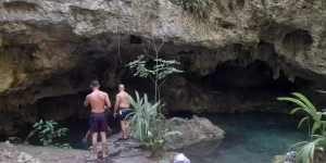 Cenote natural na selva da Riviera Maya, com águas cristalinas rodeadas por rochas e vegetação tropical.