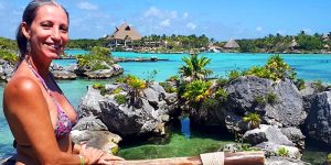 Mulher a relaxar nas águas cristalinas de Xel-Há, rodeada por natureza tropical.